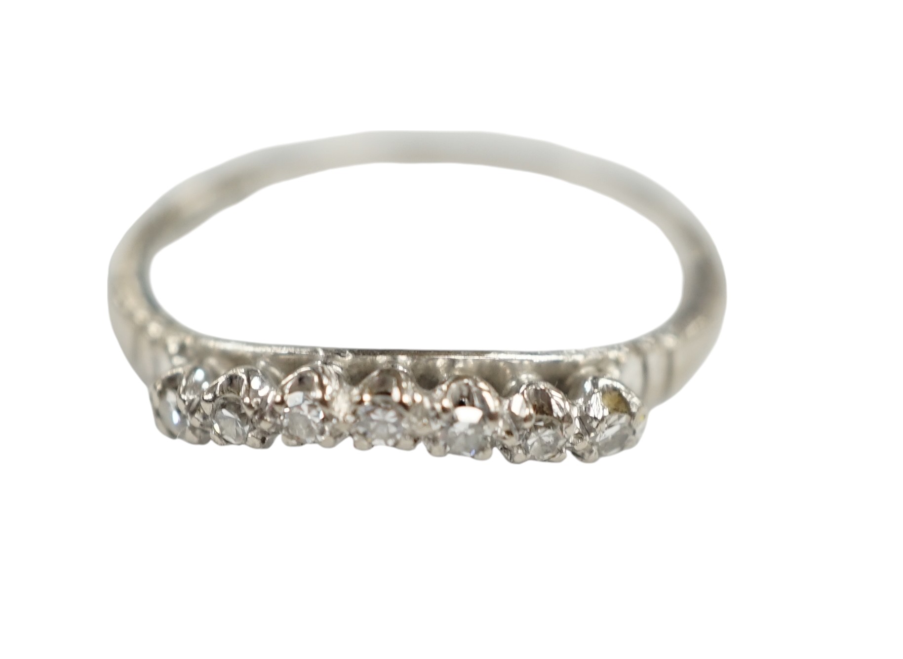 An 18ct, plat and seven stone diamond chip set 'chevron' half hoop ring, size O, gross weight 2.5 grams. Condition - fair